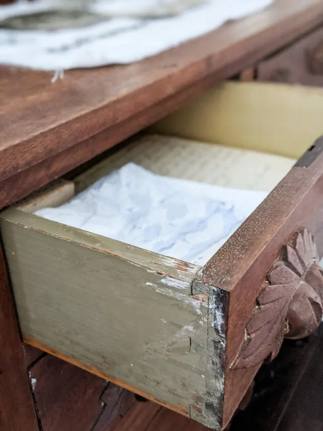 Eastlake dresser drawer with dovetail joints, carved handle, and antique linens tucked inside